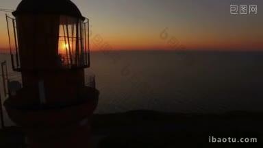 工作的老灯塔上一个日落背景在海上在夏天空中飞行的无人机经过灯塔